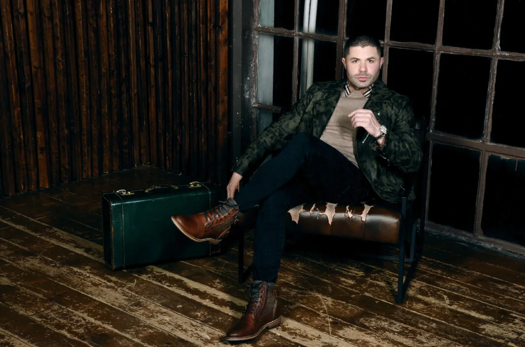 Jeffrey Wachman seated in a dark studio